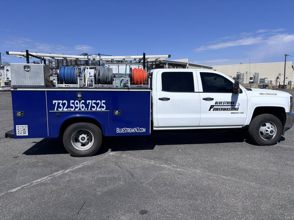 Blue Streak Powerwashing’s branded truck with ladder rack and hose reels